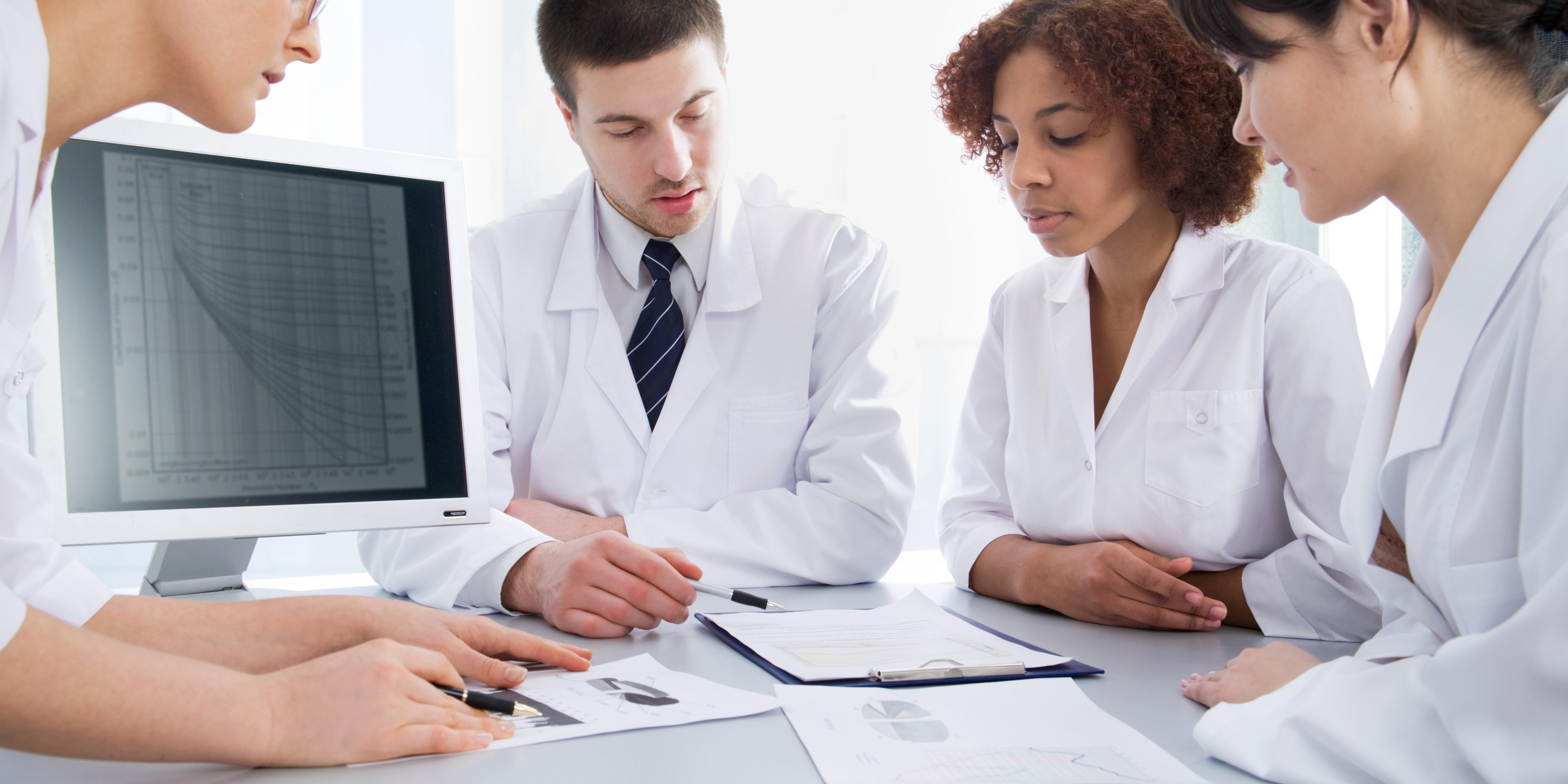 Four young doctors discussing a diagnosis Website Header 